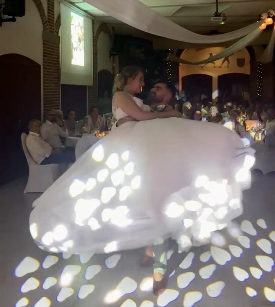 Ouverture de bal chorégraphiée d'Emma et Lucas, la robe de la mariée virevolte sous les jeux de lumière au Château de la Grange Fort