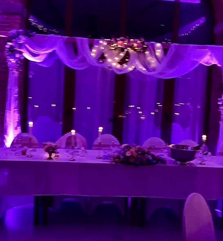 Table d'honneur décorée et mise en valeur par les lumières de salle